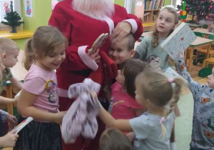 Dzieci przytulają się do Mikołaja.