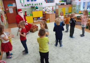 Dzieci tańczą w parach dla Mikołaja.