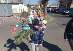 Dziewczynka niesie kukłę marzanny