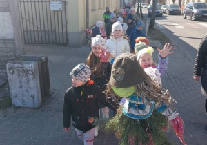 Dzieci idą na spacer wkoło przedszkola z kukłą marzanny i gaikiem.