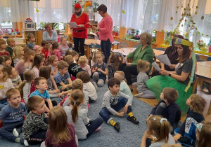 Przebudzony krasnal rozmawia z wiewiórką.