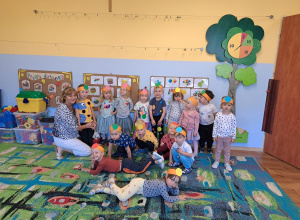 Grupa dzieci z nauczycielką – dzieci mają na głowach opaski z kolorowymi kółeczkami