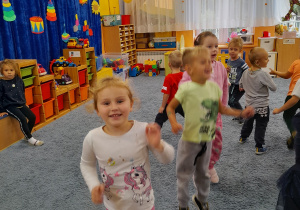 Dzieci tańczą w sali.