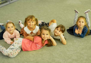 Dziewczynki leżą na dywanie