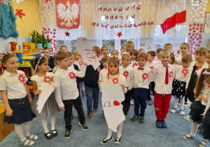 Dzieci z mapą Polski podzieloną na trzy części.
