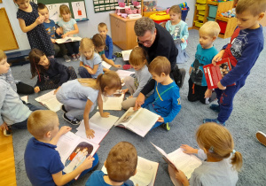 Dzieci wspólnie z autorem oglądają książki.