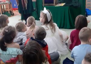 Wróżka czyta dzieciom fragment historii o Wróbelku.