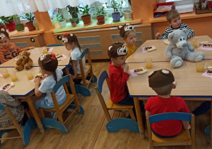 Misiowe przyjęcie- dzieci siedzą przy stolikach i delektują się słodkościami przygotowanymi przez rodziców.