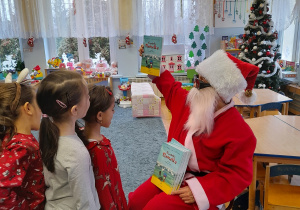 Mikołaj rozdaje dzieciom książki „O wróbelku Elemelku”.