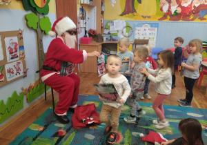 Mikołaj rozdaje dzieciom książki „Tuptuś ”.