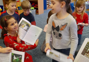 Dzieci oglądają książki od Mikołaja.