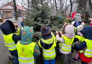 Dzieci ubierają choinkę w Alei Bożonarodzeniowej.