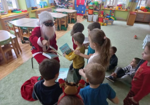 Mikołaj rozdaje dzieciom książeczki