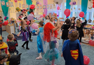 Dzieci biorą udział w konkursie odbijania baloników.