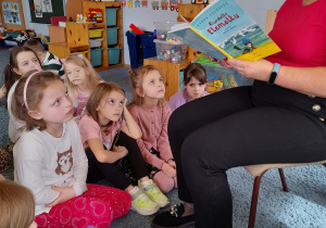 Pani Naczelnik czyta dzieciom opowiadanie w grupie V towarzyszy im maskotka wróbelka Elemelka.