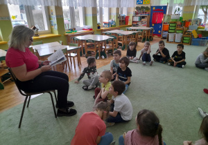 Pani Naczelnik czyta dzieciom Z grupy IV opowiadanie o wróbelku.