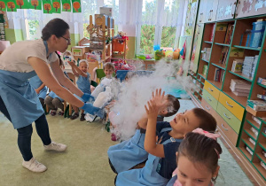 Dzieci "podziwiają" dym z suchym lodem.