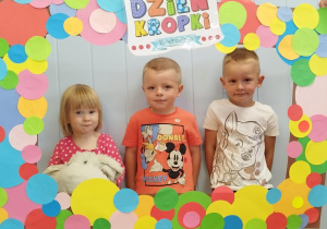 Dzieci w ramce z kolorowych kropek.