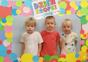 Dzieci w ramce z kolorowych kropek.