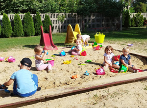 Grupa dzieci bawiących się w piaskownicy