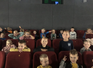 Grupa dzieci siedząca w kinie.