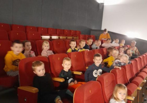 Grupa dzieci siedząca w kinie.