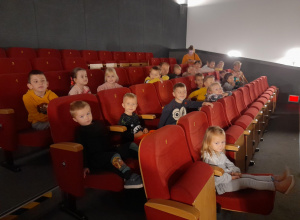 Dzieci siedzą w fotelach w oczekiwaniu na film