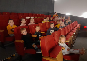 Dzieci siedzą w fotelach w oczekiwaniu na film.