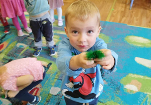 Chłopiec trzymający zielone piórko.