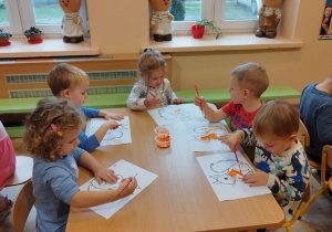 Grupa dzieci malujących farbami