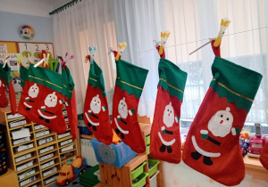 Dzieci stoją z Mikołajem w korytarzu przedszkola
