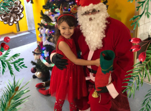 Dziewczynka pozuje ze św. Mikołajem.