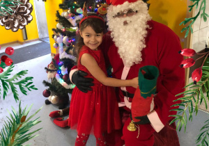 Dziewczynka pozuje ze św. Mikołajem.