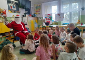 Św. Mikołaj czyta książeczkę dzieciom z grupy IV.