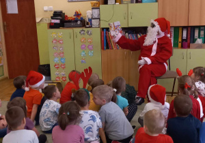 Św. Mikołaj czyta książeczkę dzieciom z grupy V.