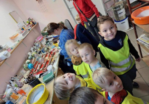 Dzieci uśmiechające się do obiektywu podczas zwiedzania fabryki bombek.