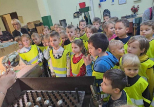 Dzieci przyglądające się procesowi tworzenia bombki.