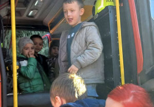 Dzieci wsiadają do wozu strażackiego