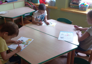 Dzieci wykonują zadanie przy stoliku