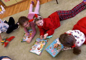 Dzieci przeglądają książeczki na dywanie
