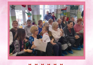 Zdjęcie w różowej ramce przedstawiające dziadków na widowni, na pierwszym planie chłopiec tuli się do babci.