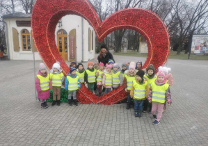 Dzieci wraz z panią nauczycielką przy wielkim czerwonym sercu.
