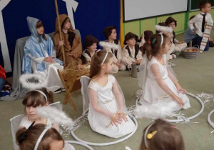 Dziewczynki-aniołki siedzą na dywanie