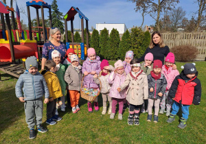Dzieci wraz z nauczycielkami w ogrodzie przedszkolnym.