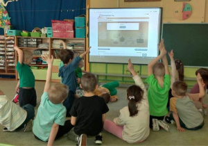 Dzieci podczas gry "Milionerzy" z wykorzystaniem tablicy demonstracyjnej.