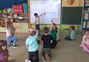 Dzieci podczas gry "Milionerzy" z wykorzystaniem tablicy demonstracyjnej.