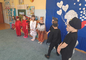 Grupa dzieci w przebraniach podczas występu dla emerytowanych nauczycieli i pracowników przedszkola.