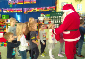 Mikołaj rozdaje dzieciom cukierki