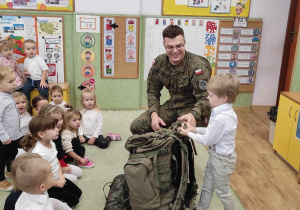 Żołnierz prezentuje ekwipunek żołnierski.