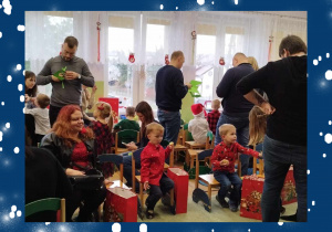 Dzieci i rodzice oglądają prezenty od Świętego Mikołaja.